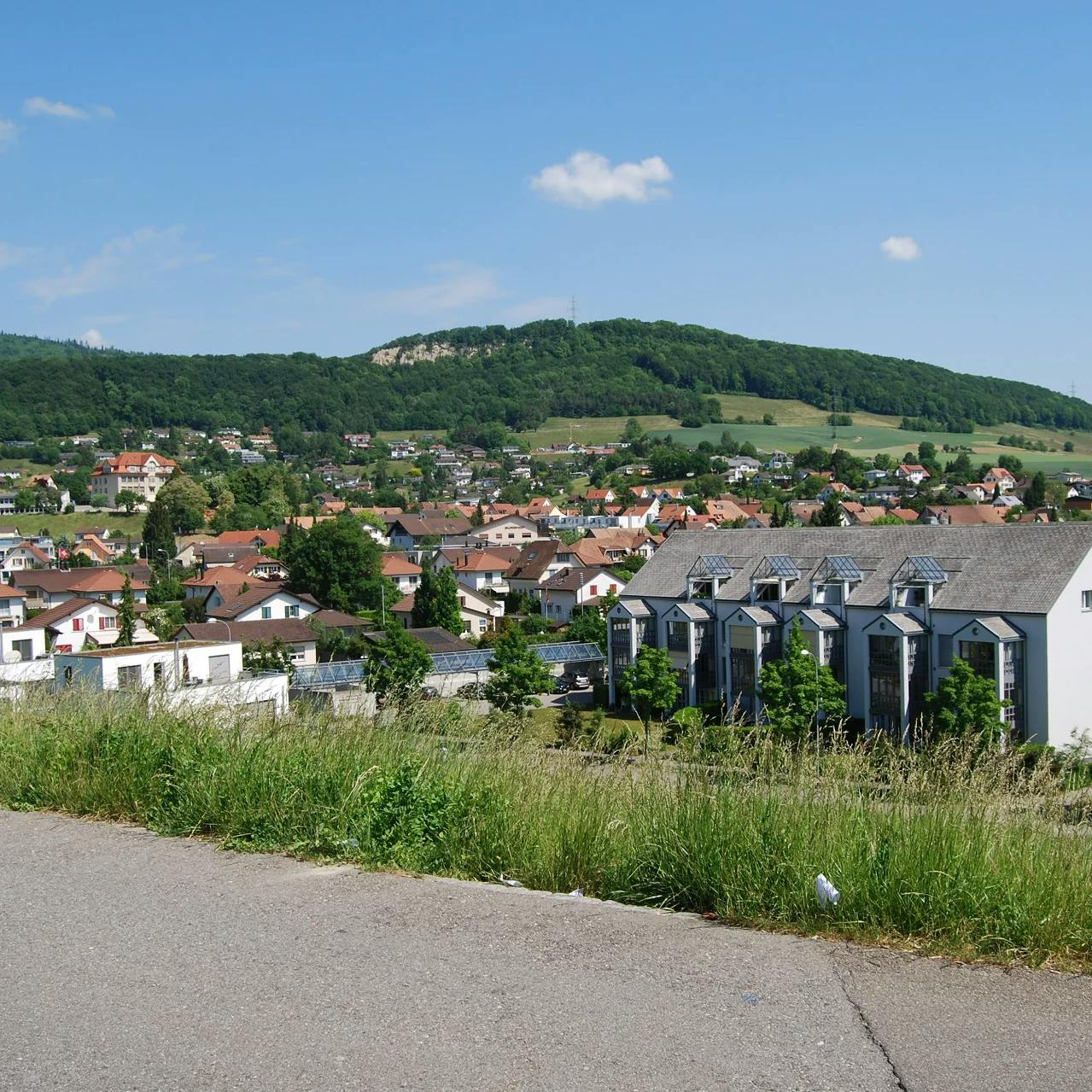 Blick auf die Ortschaft Lostorf und die Hügel dahinter, von einem erhöhten Punkt ausserhalb des Dorfes.