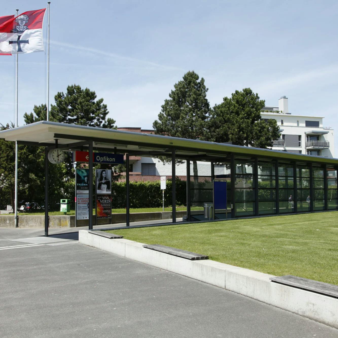 Bahnhofansicht Opfikon mit Gemeinde- und Schweizer Flagge